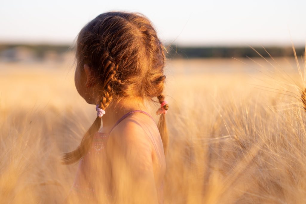 Girl with pigtails standing in a field